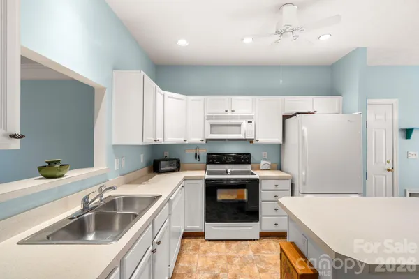 a kitchen that has a sink a stove and a refrigerator
