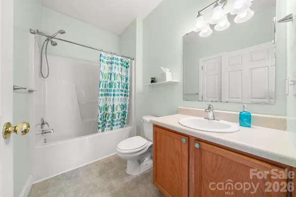 a bathroom with a granite countertop sink a toilet a mirror and shower