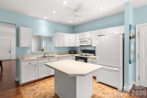 a kitchen with a refrigerator a sink and a stove top oven