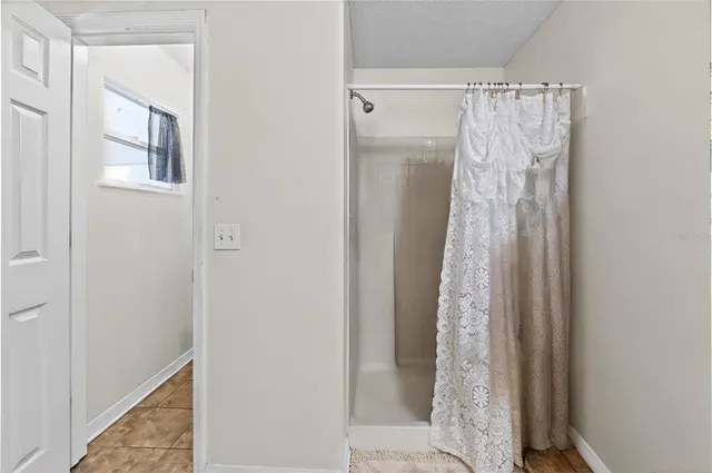 an empty room with a ceiling fan and a window