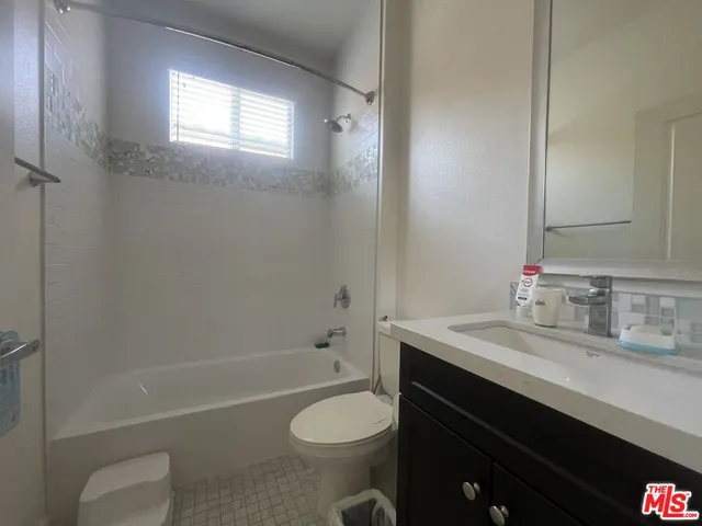 a bathroom with a sink toilet vanity and shower