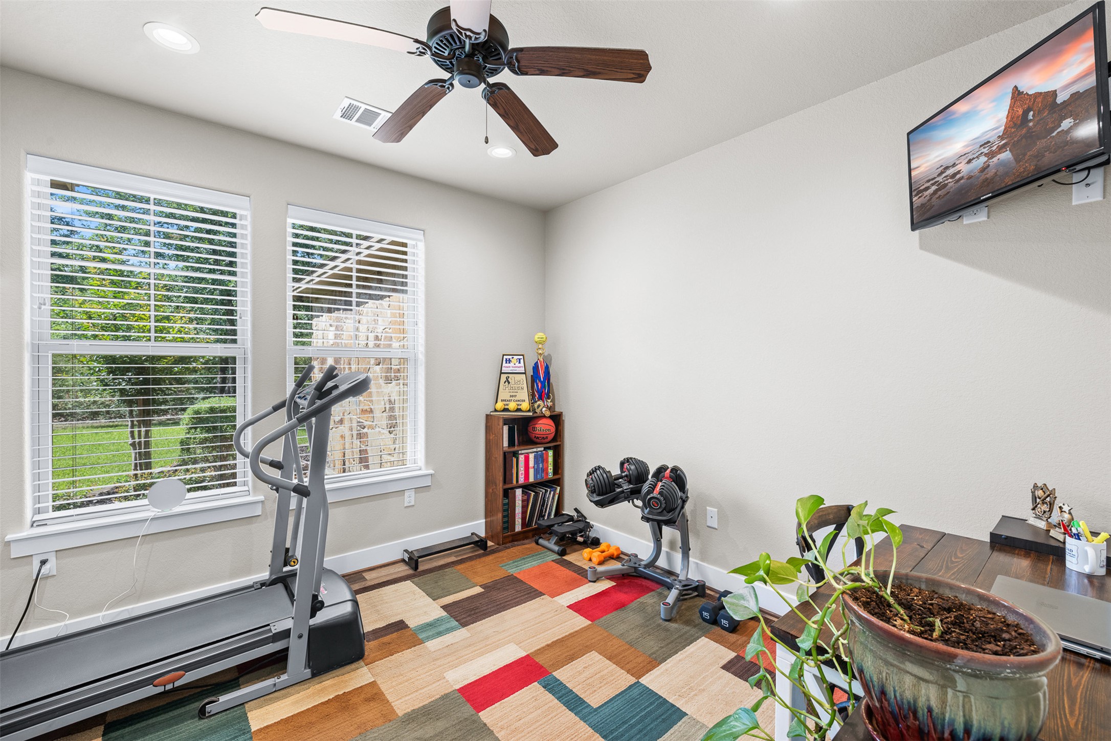 1306 22 Hills Road Gause, TX 77857 - Photo 10 of 40 Bright room featuring two windows with white blinds, a ceiling fan with integrated lighting, recessed ceiling lights, and a built-in wooden bookshelf
