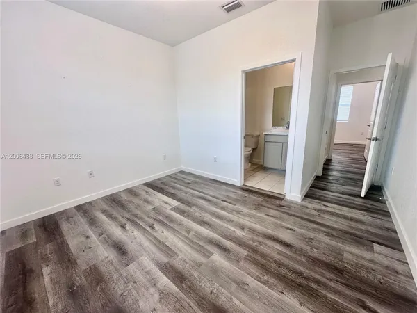 a view of a room with wooden floor