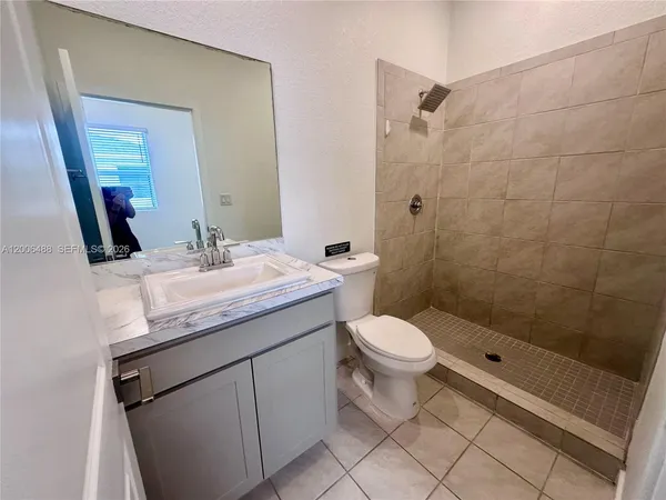 a bathroom with a granite countertop sink toilet and shower