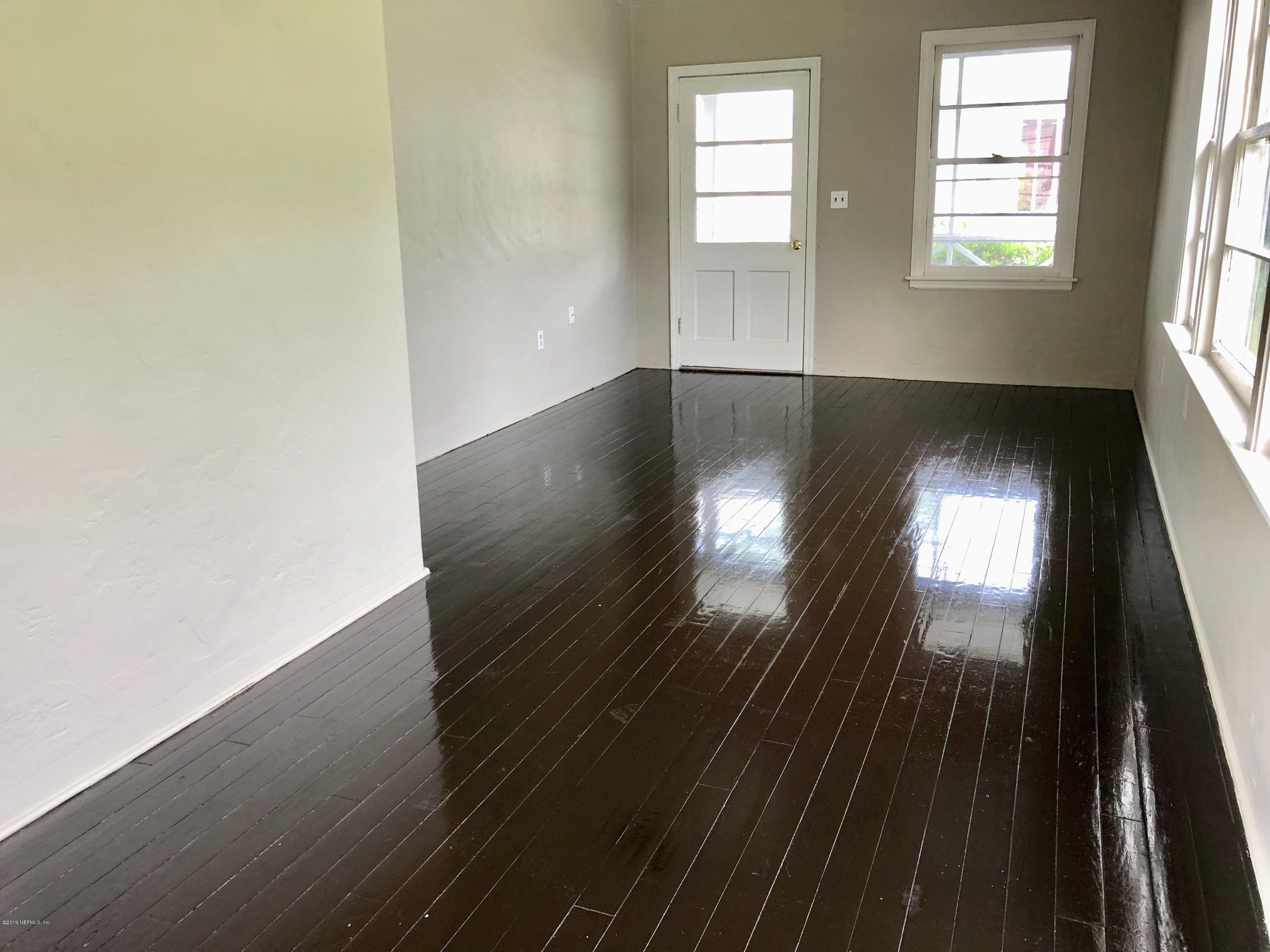 5146 Sunderland Road Jacksonville, FL 32210 - Photo 4 of 10 an empty room with wooden floor and windows