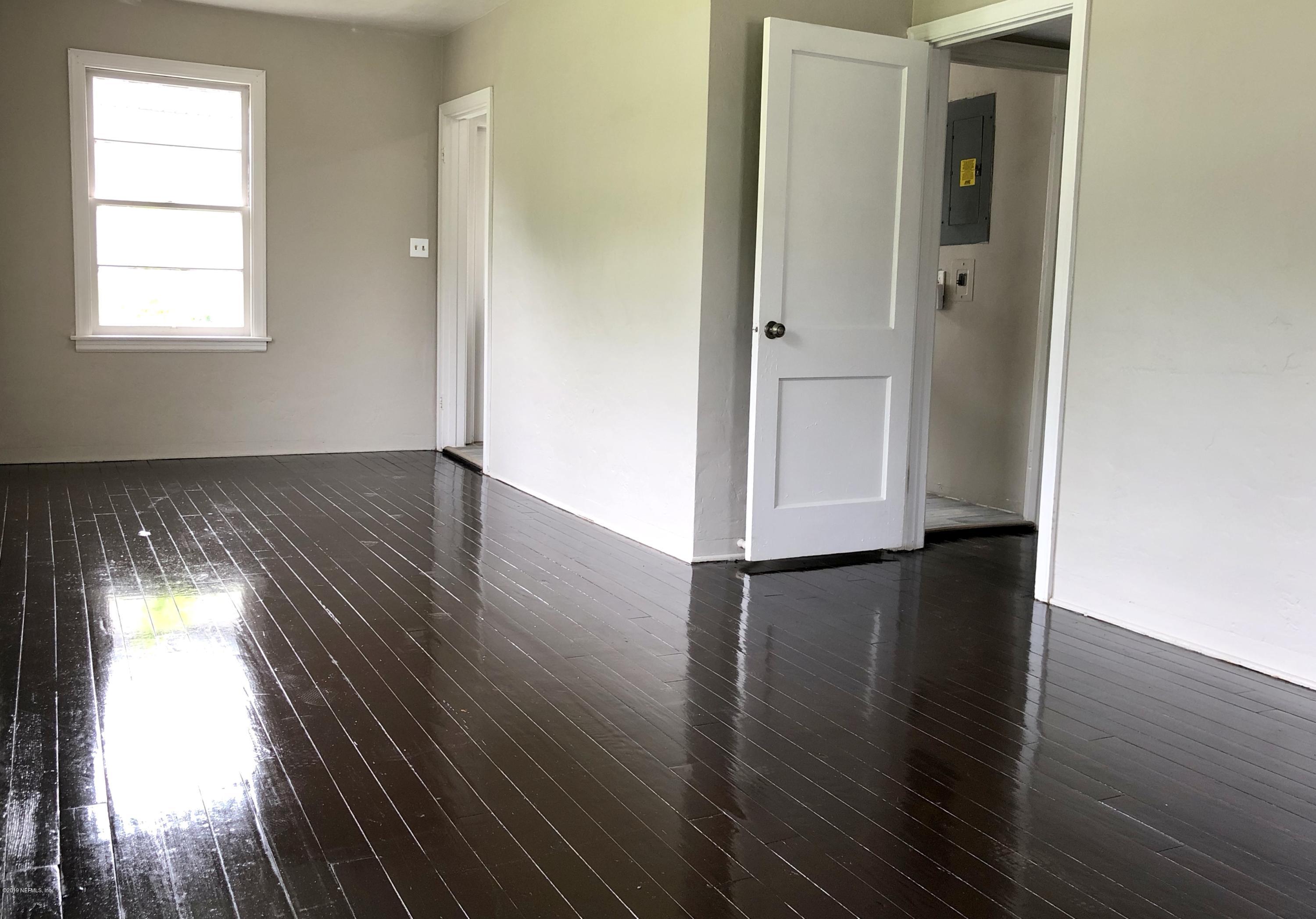 5146 Sunderland Road Jacksonville, FL 32210 - Photo 5 of 10 an empty room with wooden floor and windows