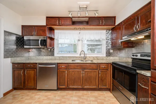 a kitchen with stainless steel appliances granite countertop a sink stove and cabinets