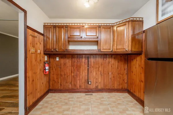 a view of a utility room with wooden floor and cabinets