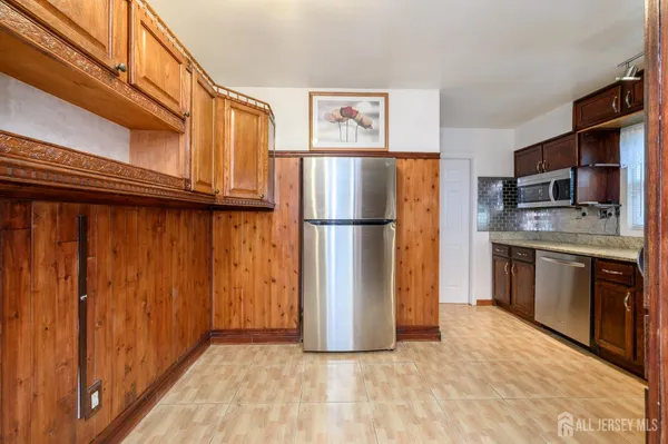 a view of kitchen with stainless steel appliances granite countertop a refrigerator and a stove top oven