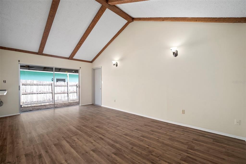 810 Black Knight Drive Valrico, FL 33594 - Photo 9 of 44 a view of an empty room with wooden floor and a window