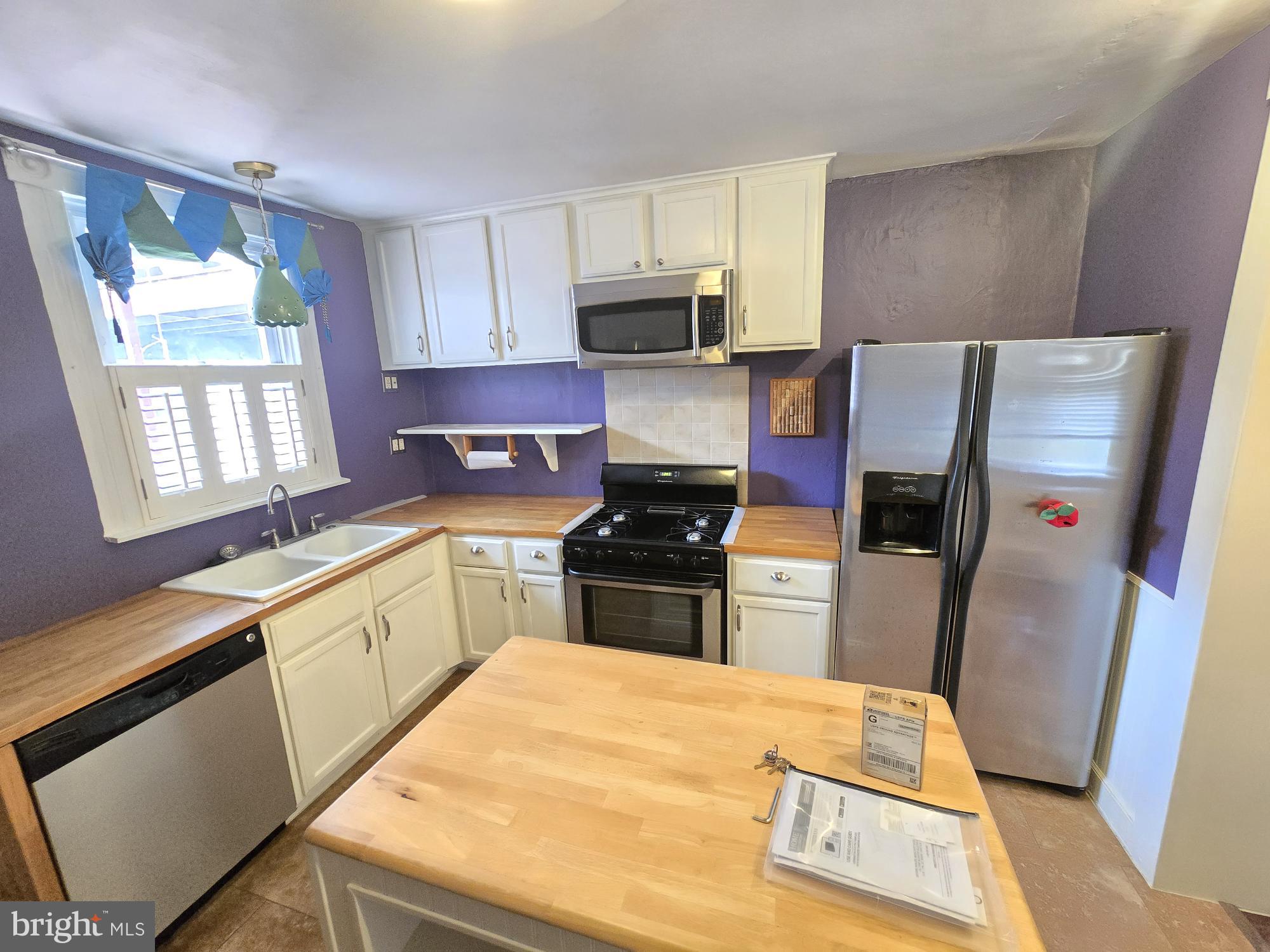 2 North Luzerne Avenue Baltimore, MD 21224 - Photo 11 of 31 a kitchen with stainless steel appliances a refrigerator sink and stove