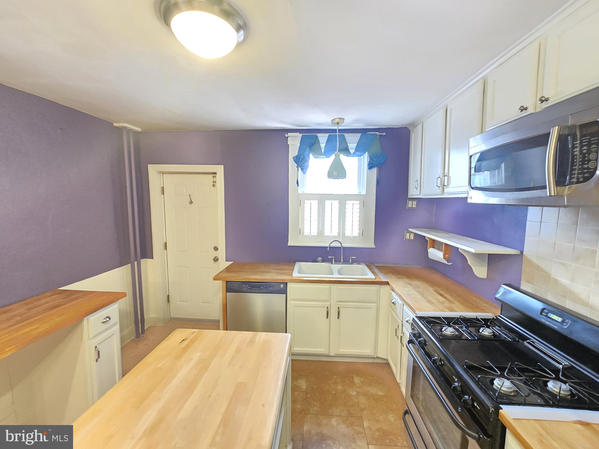 2 North Luzerne Avenue Baltimore, MD 21224 - Photo 13 of 31 a kitchen with a stove a sink and a refrigerator