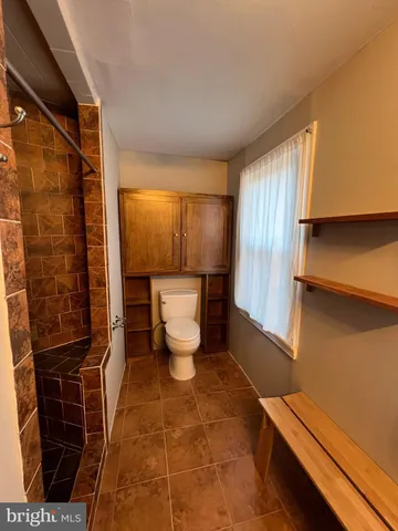 a bathroom with a sink a toilet a mirror and bathtub