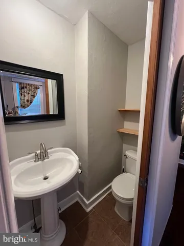 a bathroom with a toilet a sink and mirror