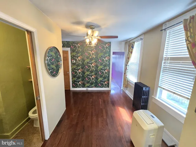 a view of a hallway with furniture window and wooden floor