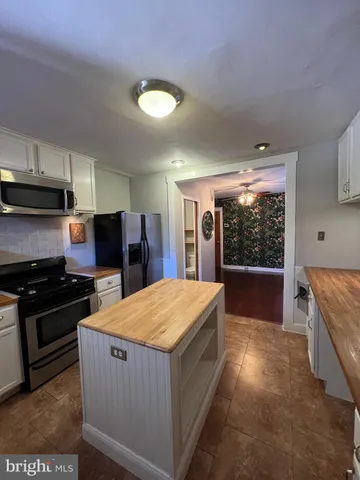 a kitchen with stainless steel appliances granite countertop a stove a refrigerator and a sink