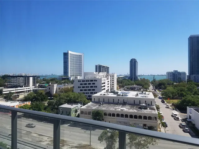 a living room with furniture a flat screen tv and a floor to ceiling window