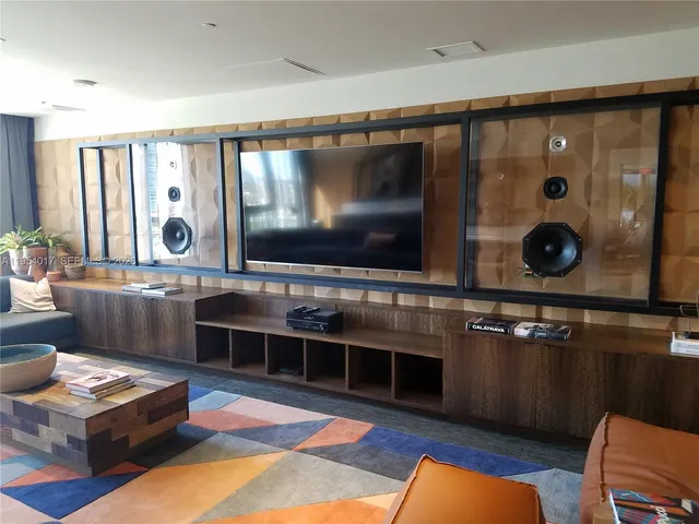 a living room with furniture flat screen tv and a large window