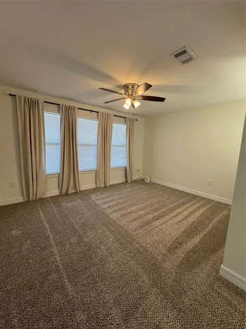 a view of an empty room with a chandelier fan