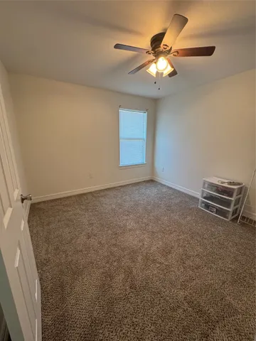 an empty room with a ceiling fan and fan