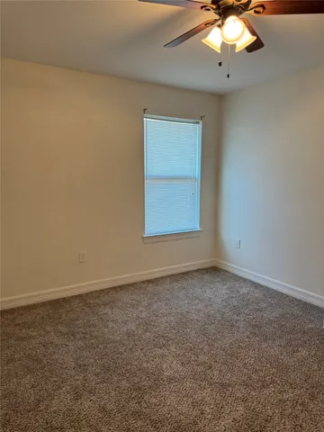 an empty room with a chandelier fan