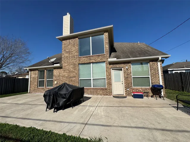 a front view of a house with barbeque oven and table