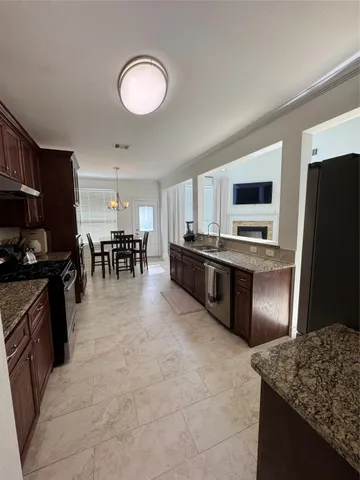 a kitchen with stainless steel appliances granite countertop a stove refrigerator and a microwave