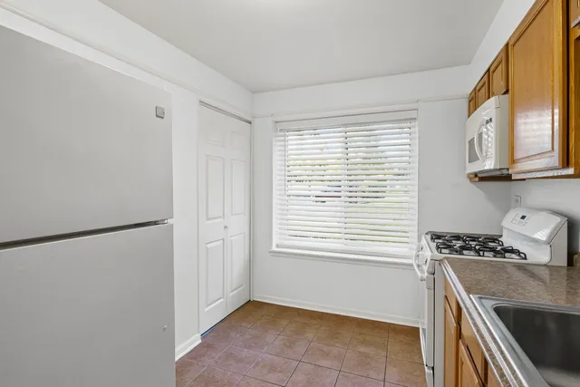 a kitchen with a window a refrigerator and a stove top oven
