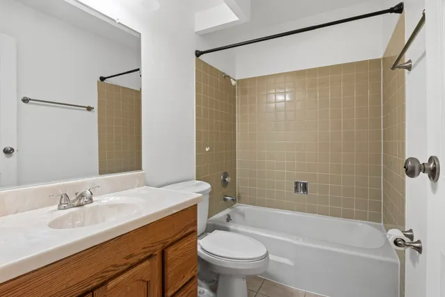 a bathroom with a granite countertop sink a toilet and shower