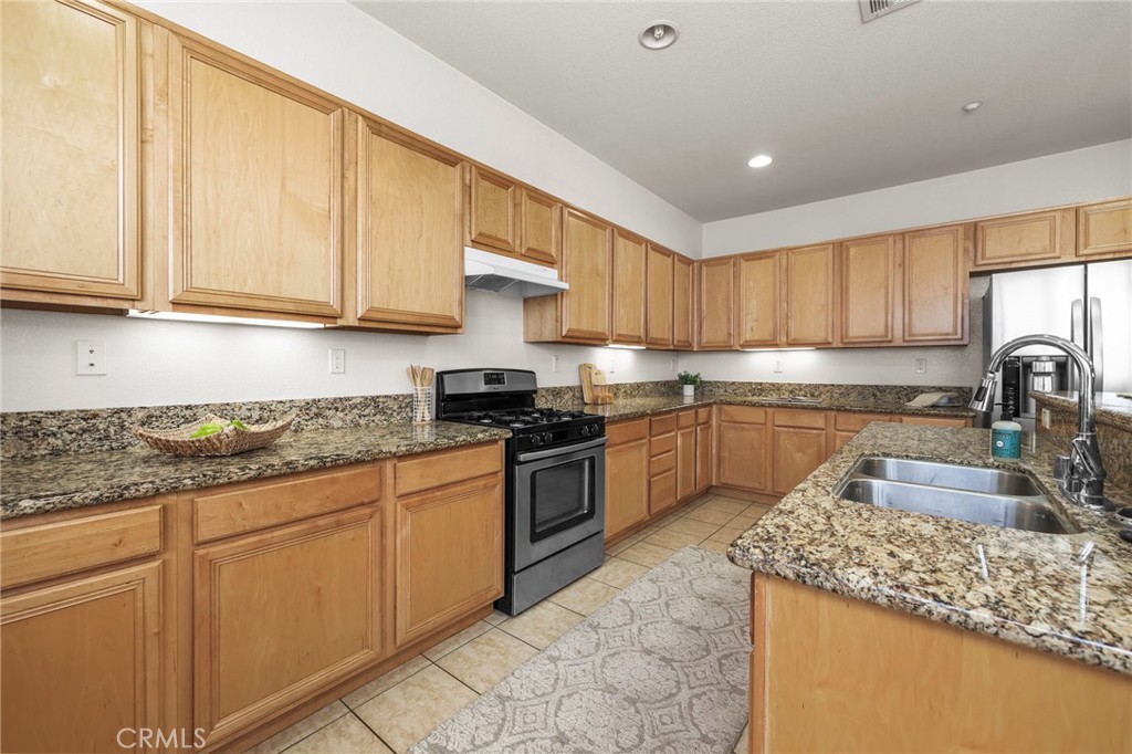 10375 Church, Unit 124 Rancho Cucamonga, CA 91730 - Photo 12 of 34 a kitchen with granite countertop a sink stainless steel appliances and cabinets
