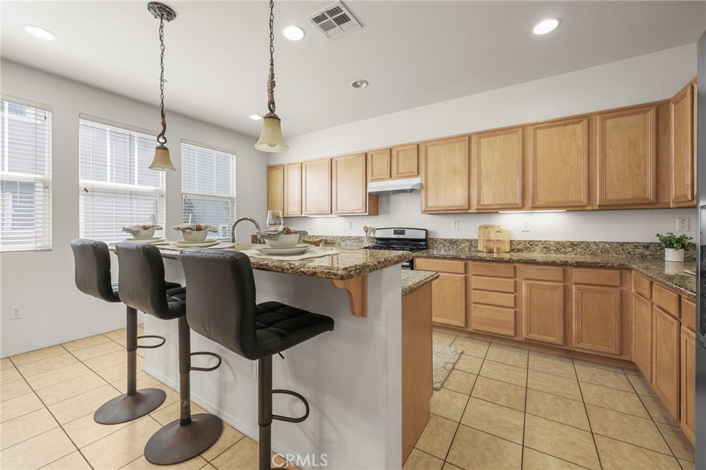 10375 Church, Unit 124 Rancho Cucamonga, CA 91730 - Photo 13 of 34 a kitchen with stainless steel appliances granite countertop a sink a stove a refrigerator cabinets and chairs