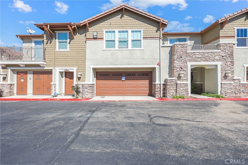 10375 Church, Unit 124 Rancho Cucamonga, CA 91730 - Photo 3 of 34 a front view of a house with a yard and garage