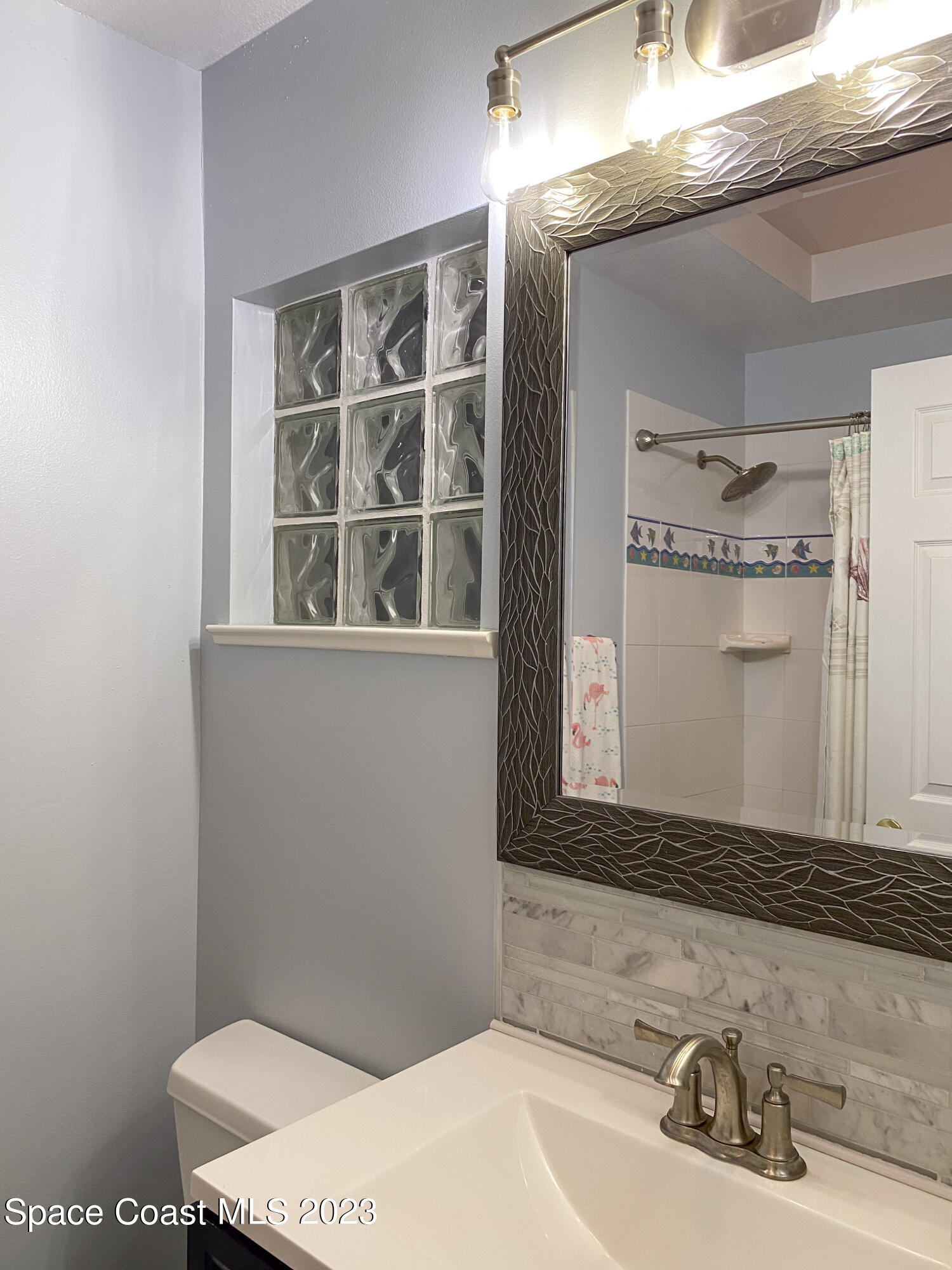 5080 Seiler Street Melbourne Beach, FL 32951 - Photo 19 of 34 a bathroom with a sink a toilet and a mirror