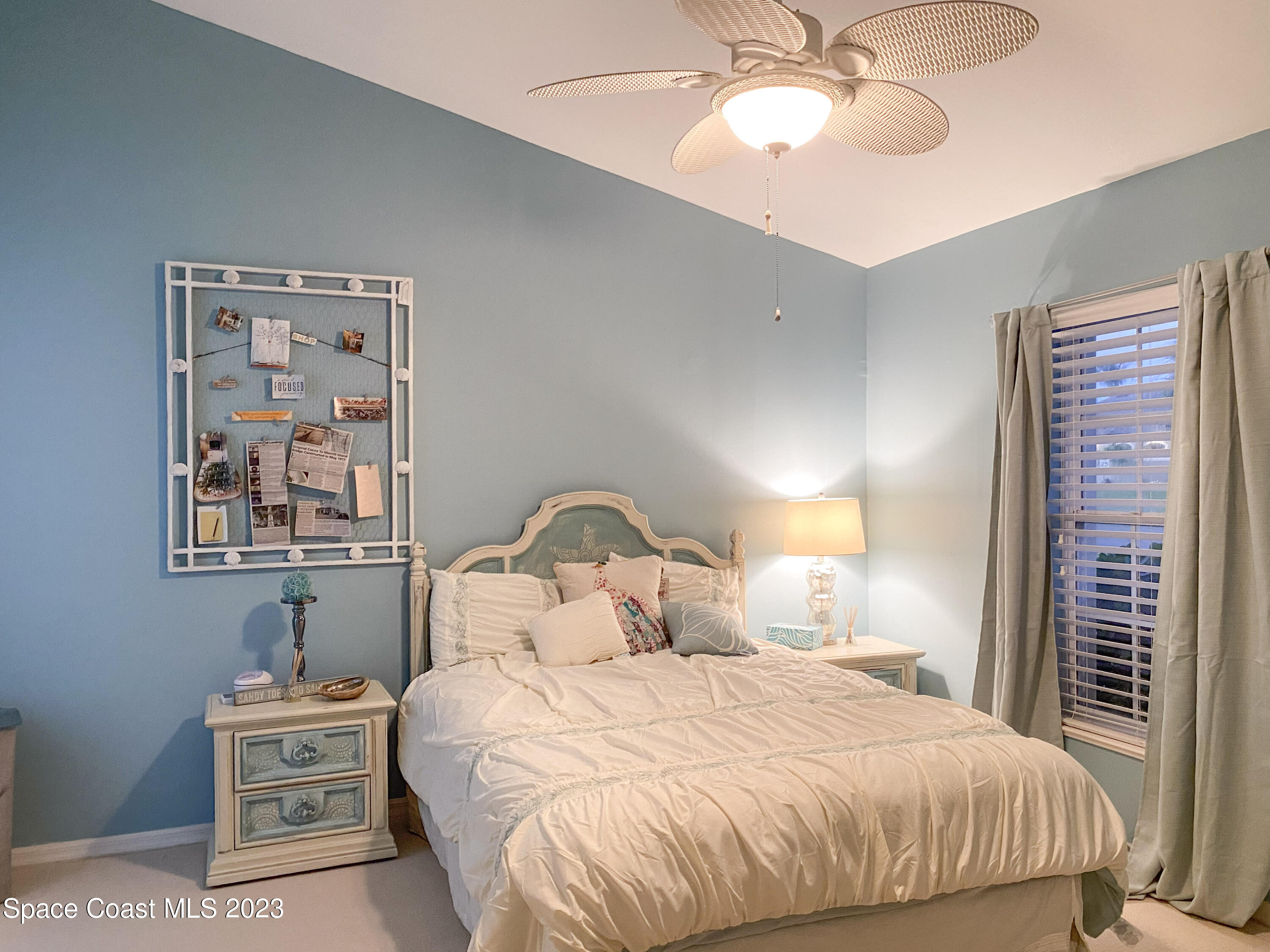 5080 Seiler Street Melbourne Beach, FL 32951 - Photo 20 of 34 a bedroom with a bed and a chandelier