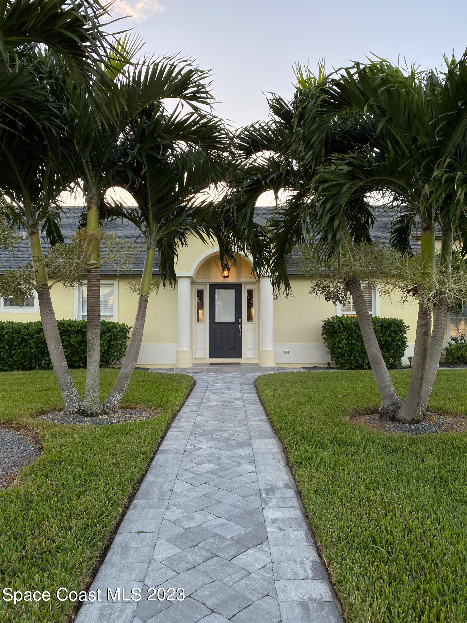 5080 Seiler Street Melbourne Beach, FL 32951 - Photo 2 of 34 a front view of a house with a yard and potted plants