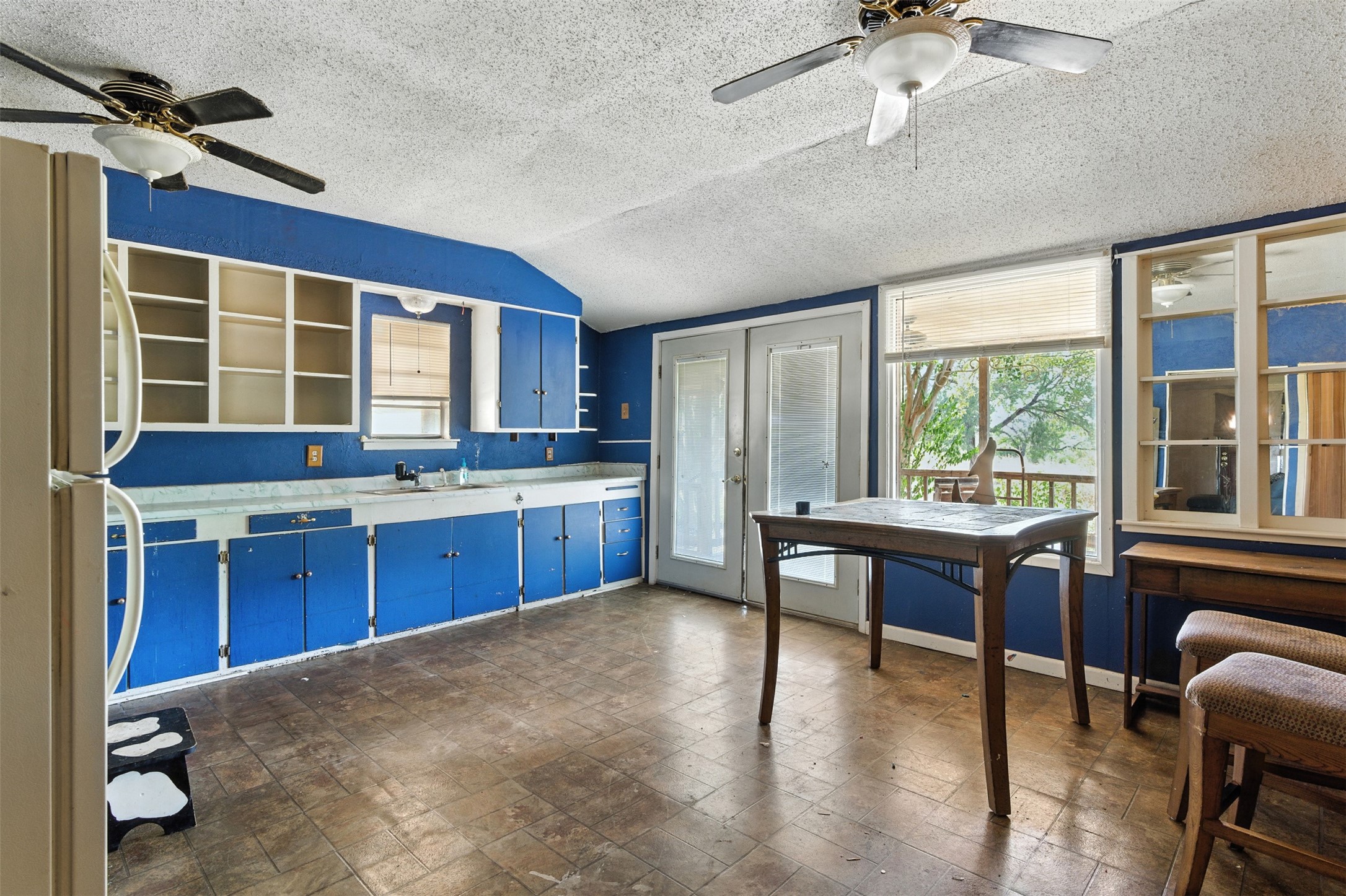 4672 Rakowitz Road Adkins, TX 78101 - Photo 10 of 38 The kitchen and dining space includes overhead fans for comfort, with double doors opening to the back porch for easy indoor-outdoor living.