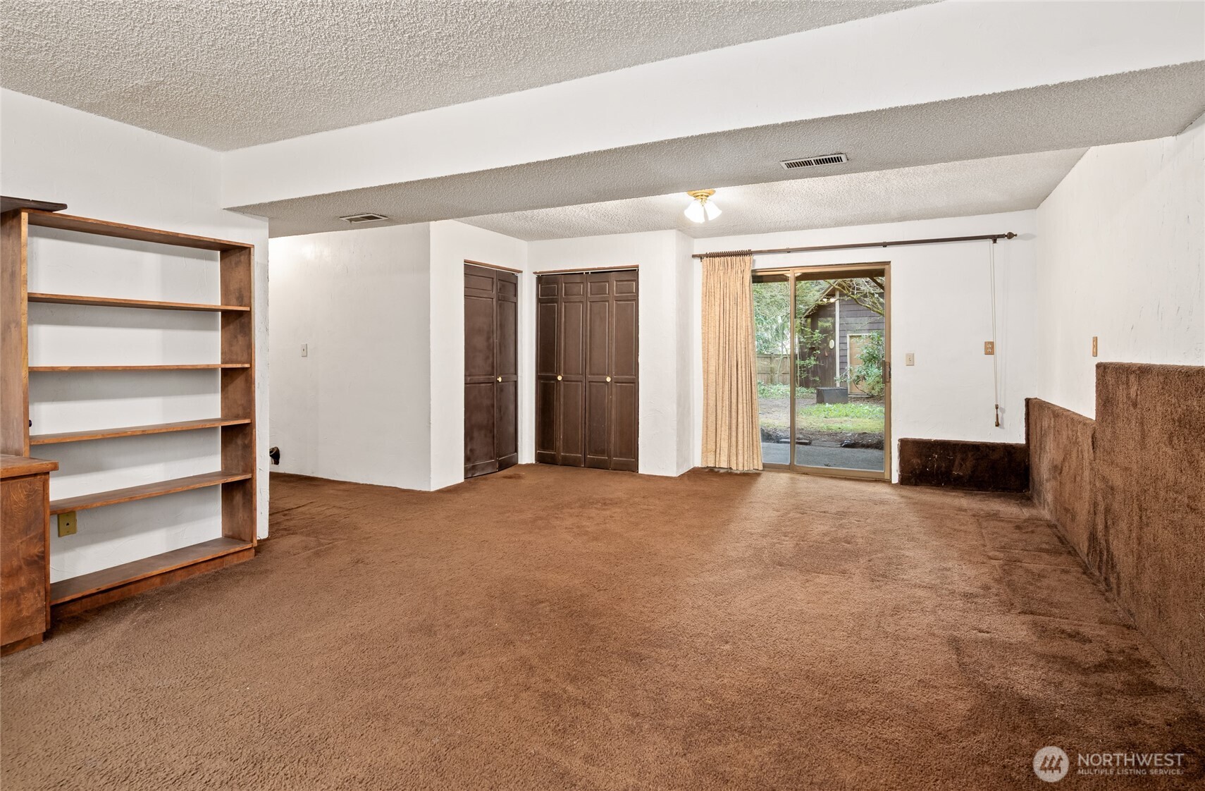 14606 60th Place West Edmonds, WA 98026 - Photo 20 of 27 a view of an empty room with a fireplace and a window
