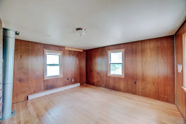 an empty room with windows and closet