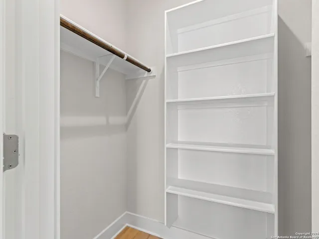 a view of walk in closet with empty racks