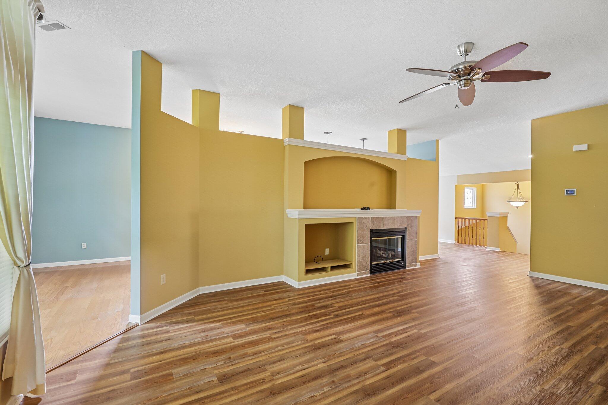 876 Flint Ridge Newport, KY 41076 - Photo 2 of 43 Living area featuring wood-finish flooring, a built-in entertainment center with an arched niche, a tiled fireplace, and a ceiling fan