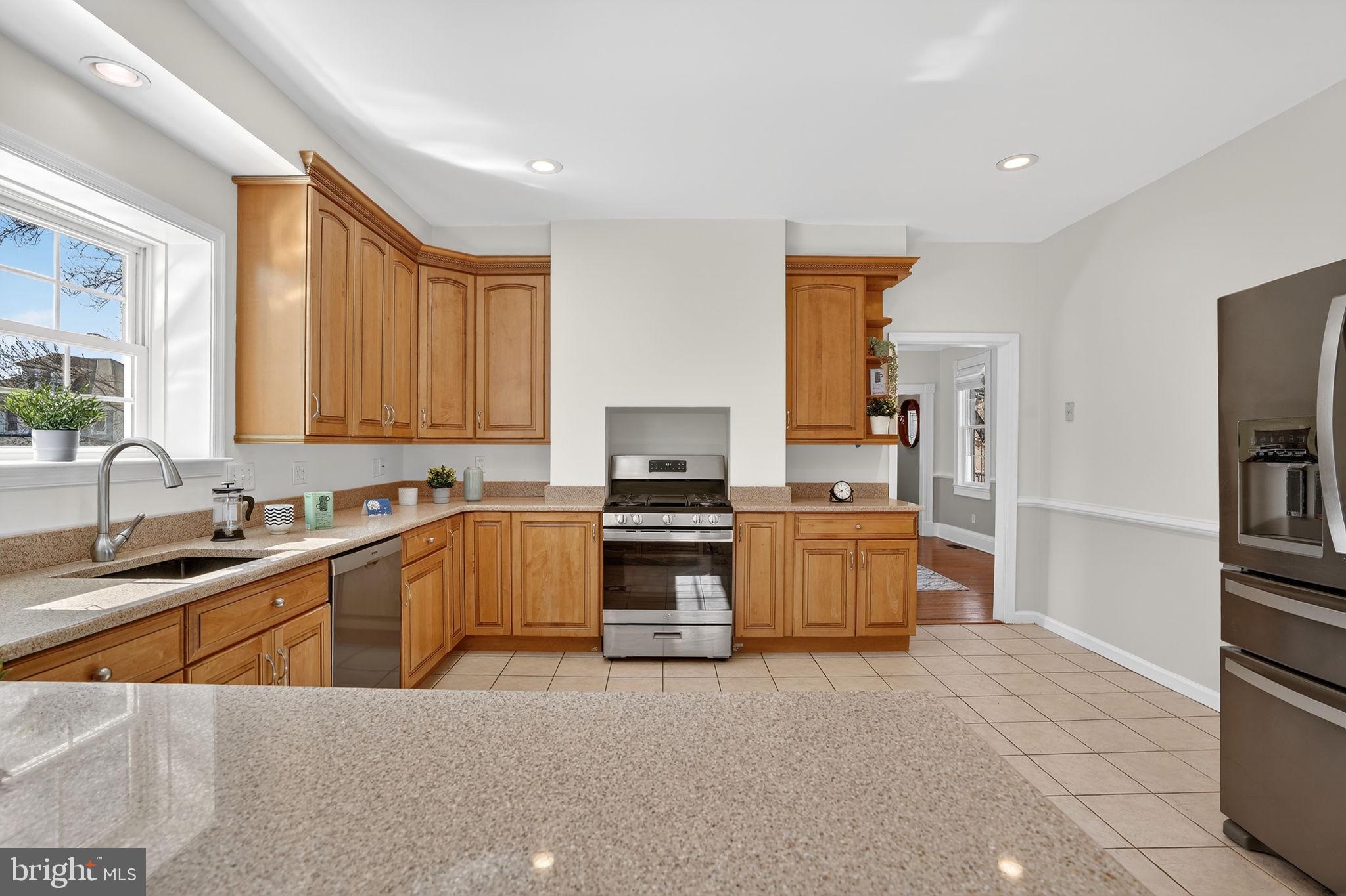 1007 Roland Heights Avenue Baltimore, MD 21211 - Photo 11 of 78 a kitchen with stainless steel appliances a stove sink and a refrigerator