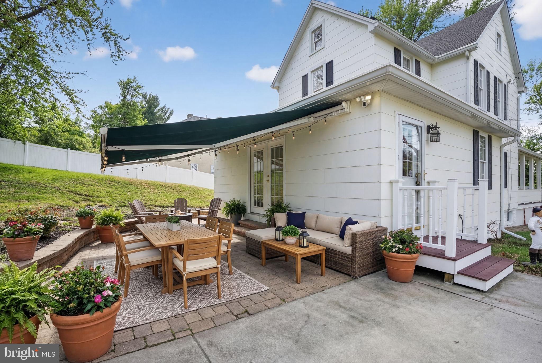 1007 Roland Heights Avenue Baltimore, MD 21211 - Photo 27 of 78 a view of a patio with table and chairs potted plants and a large tree