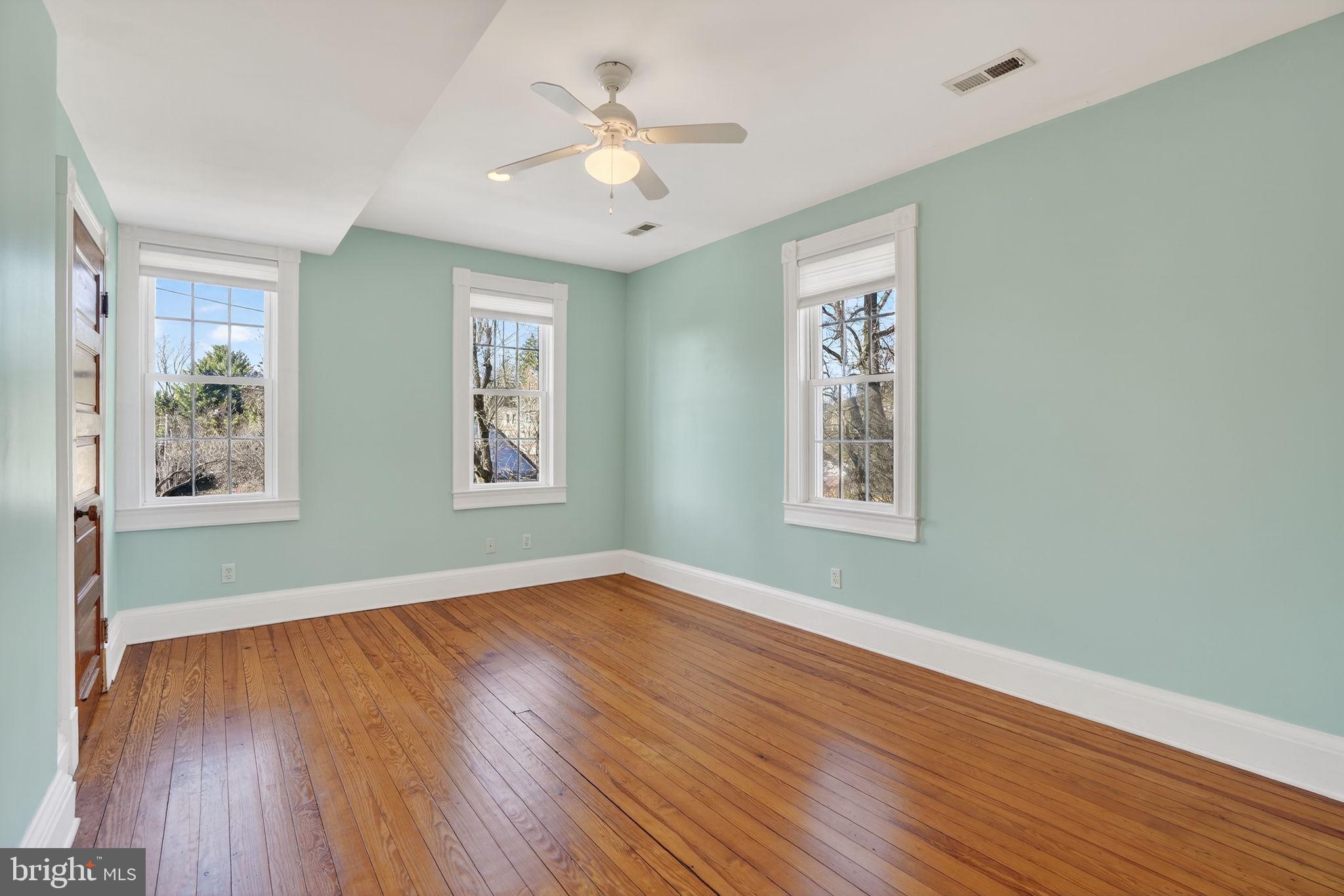 1007 Roland Heights Avenue Baltimore, MD 21211 - Photo 48 of 78 a view of an empty room with window and wooden floor