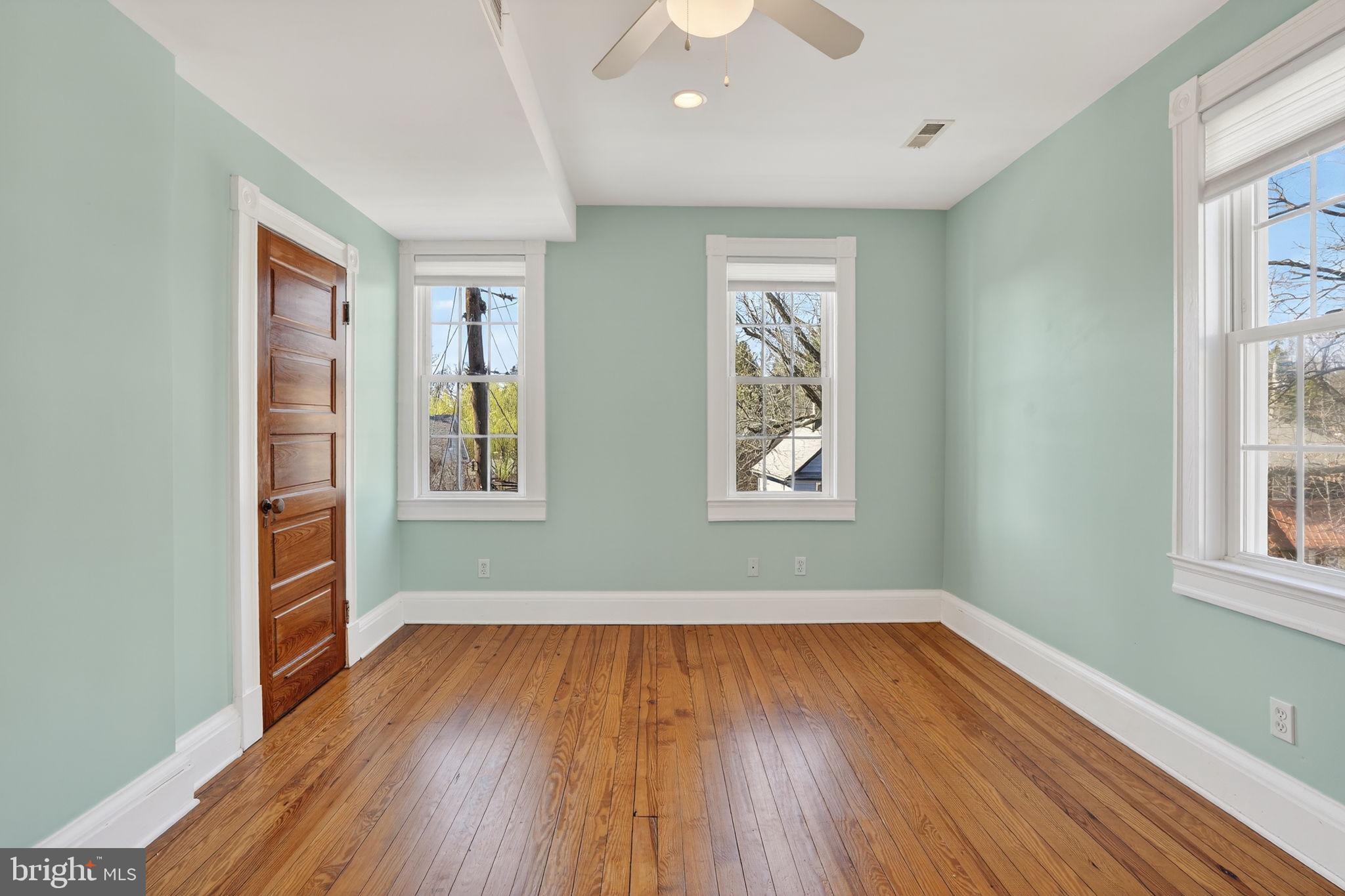 1007 Roland Heights Avenue Baltimore, MD 21211 - Photo 49 of 78 an empty room with wooden floor and windows