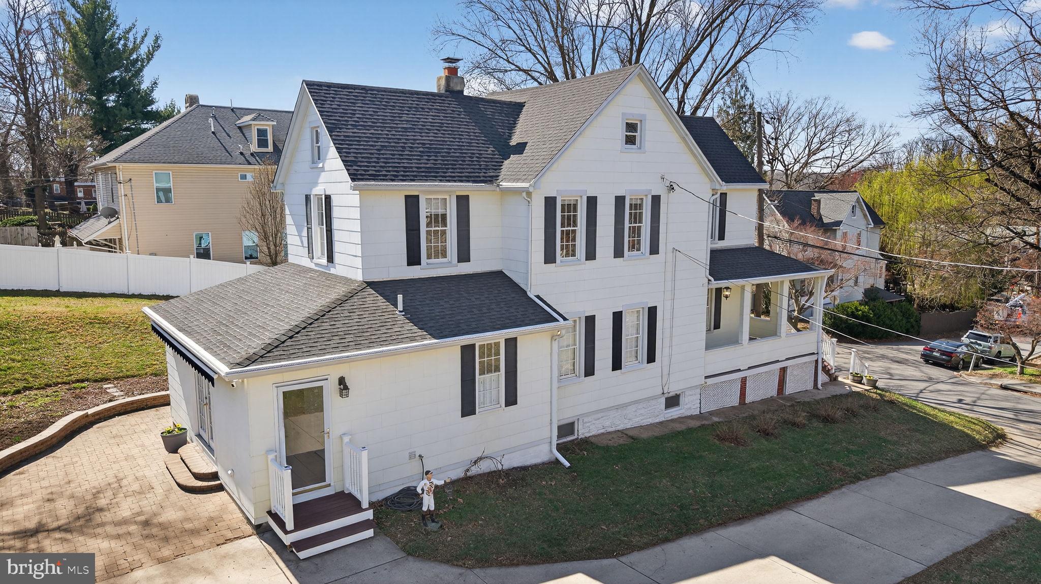 1007 Roland Heights Avenue Baltimore, MD 21211 - Photo 53 of 78 a view of a white house next to a yard with plants and trees