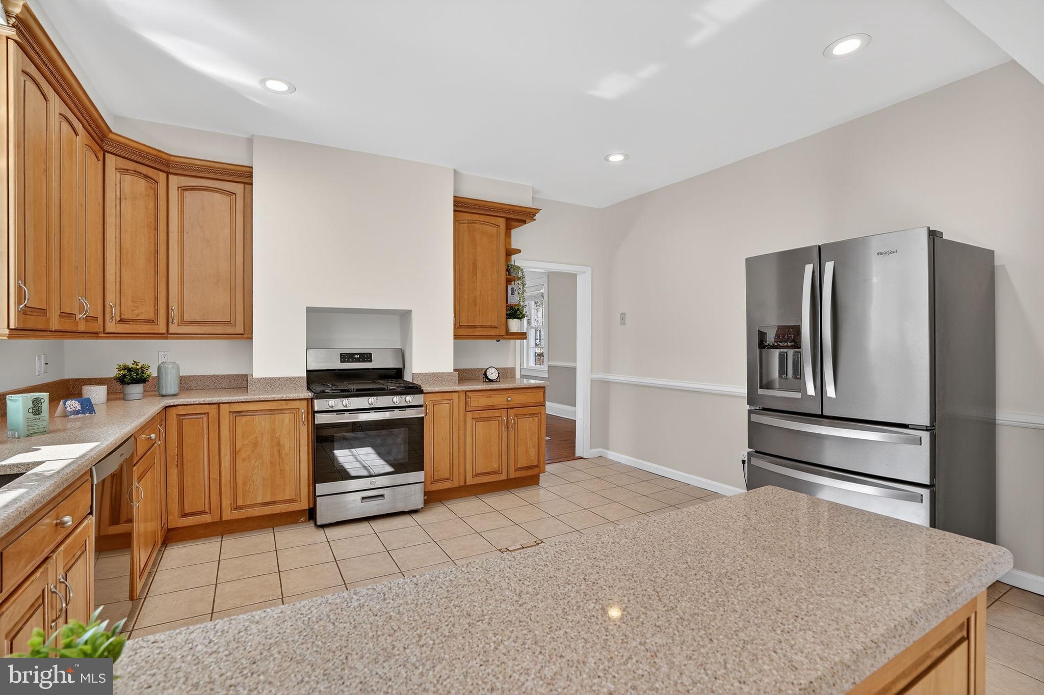 1007 Roland Heights Avenue Baltimore, MD 21211 - Photo 10 of 78 a kitchen with granite countertop a refrigerator and a stove top oven