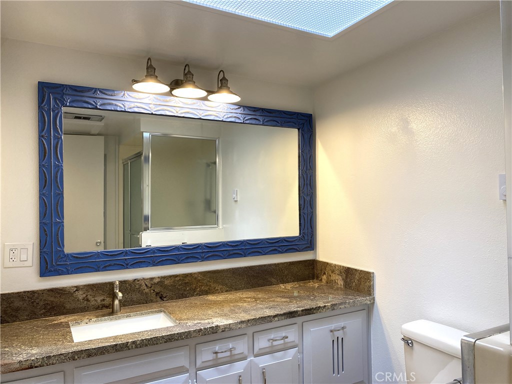 1681 Monterey Road Seal Beach, CA 90740 - Photo 20 of 23 a bathroom with a granite countertop sink and a mirror