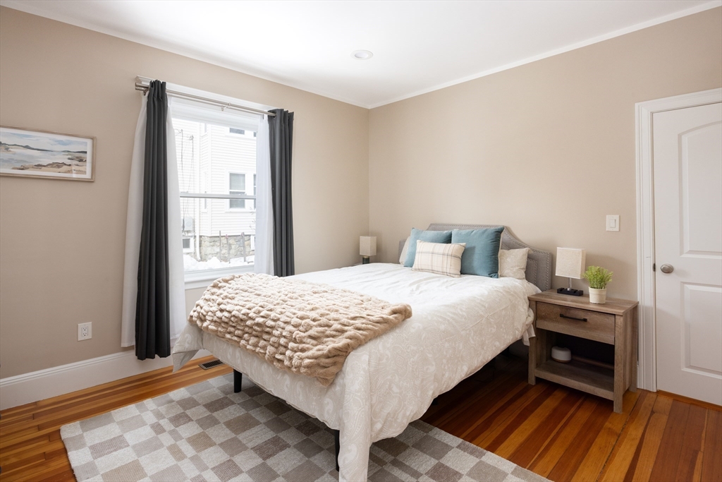 45 Bates Road, Unit 45 Watertown, MA 02472 - Photo 7 of 19 a bedroom with a bed and wooden floor