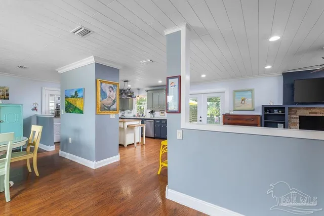 a living room with stainless steel appliances furniture and a view of kitchen