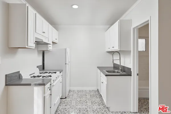 a kitchen with stainless steel appliances granite countertop a sink stove and cabinets